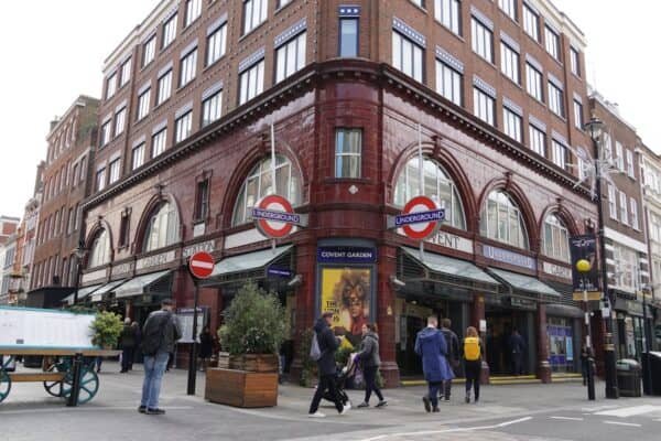 people passing by red painted building