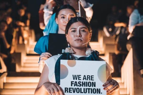 woman in blue shirt holding white paper